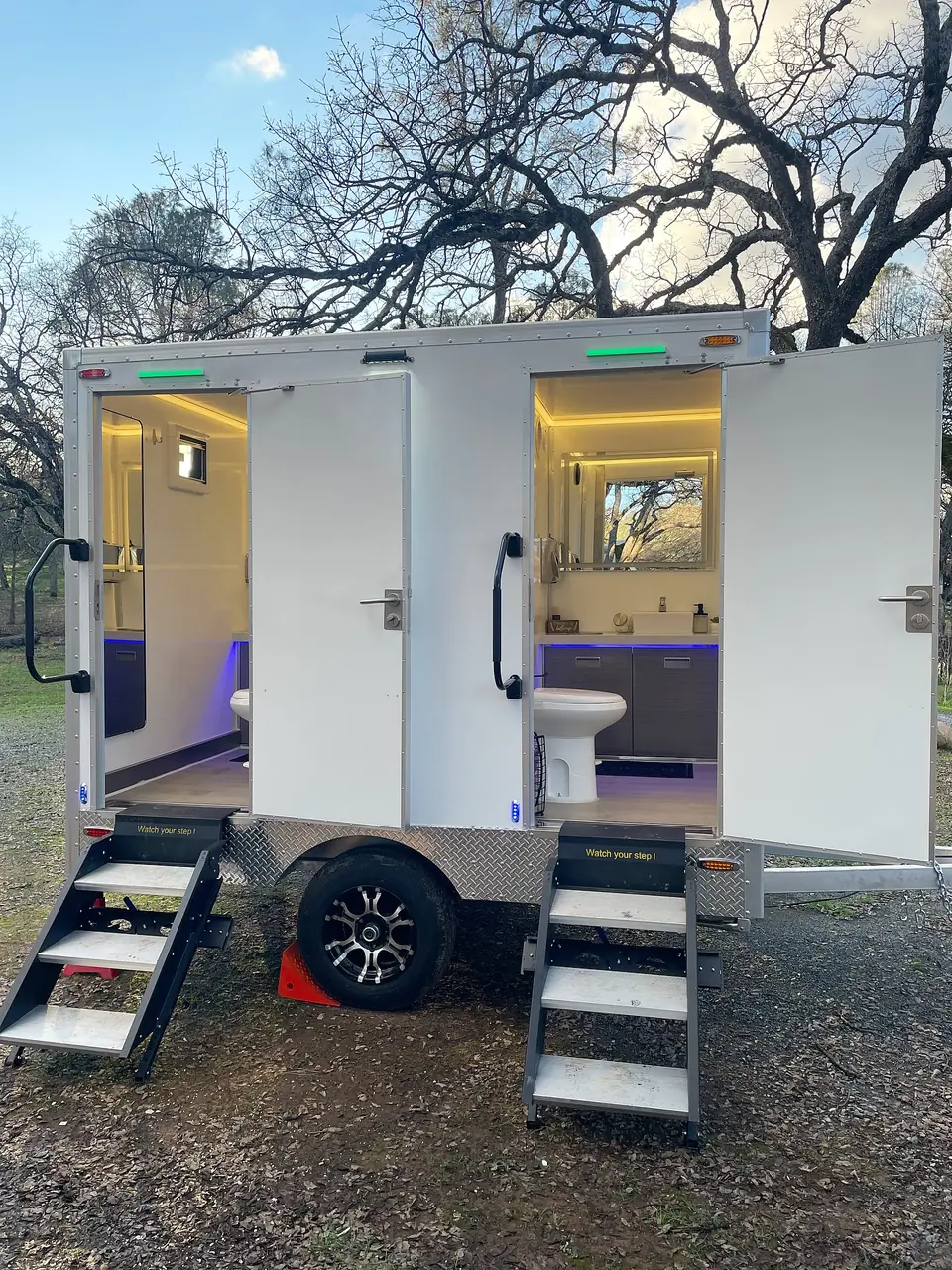 Restroom trailer at dusk with its interior lights on