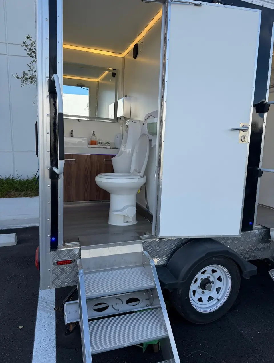 Restroom trailer interior with wood vanity and steps at the door